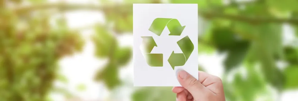 Hand hält Recycling-Symbol vor Naturhintergrund Hand hält Recycling-Symbol vor Naturhintergrund