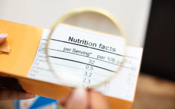 Lebensmittel Etikett vergrößert mit einer Lupe und Angaben zu den Nährwerten des Produkts. Lebensmittel Etikett vergrößert mit einer Lupe und Angaben zu den Nährwerten des Produkts.