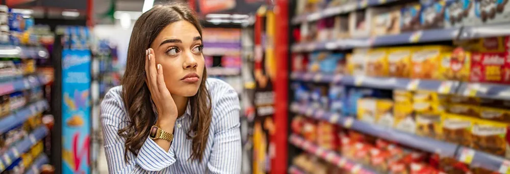 Frau im Supermarkt am Überlegen Frau im Supermarkt am Überlegen