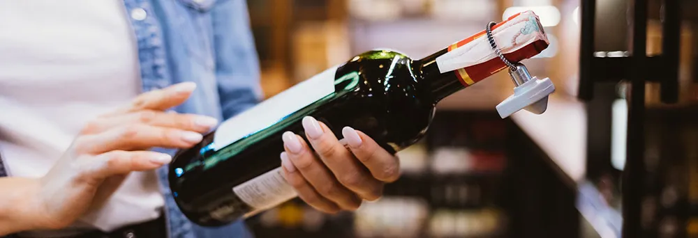 Frau liest Etikett einer Weinflasche Frau liest Etikett einer Weinflasche