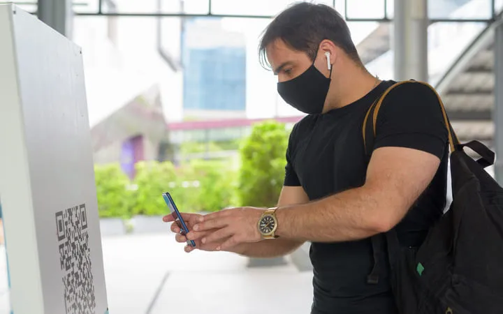 Mann scannt einen QR-Code ein Mann scannt einen QR-Code ein