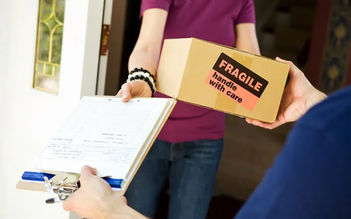 Übergabe eines Pakets mit Fragile Etikett Übergabe eines Pakets mit Fragile Etikett