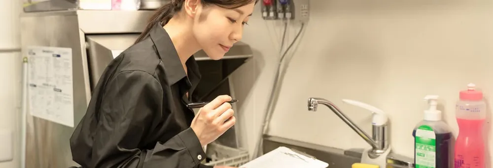 Frau überprüft die Lebensmittelhygiene nach dem HACCP-Konzept Frau überprüft die Lebensmittelhygiene nach dem HACCP-Konzept