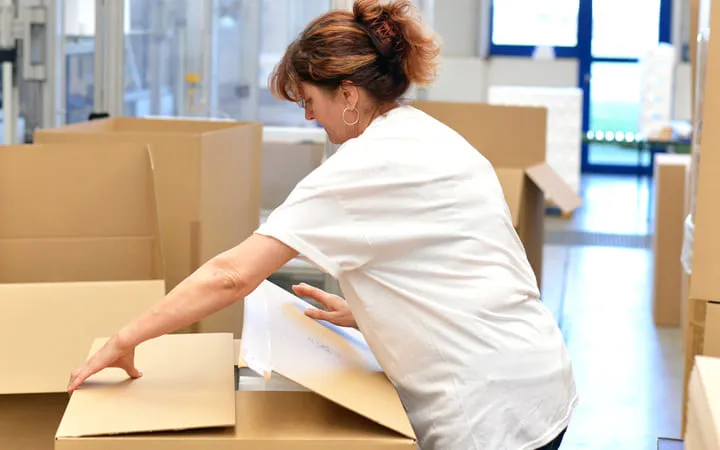 Frau am Kartons Verpacken 