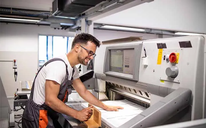 Fertig bedrucktes Papier das zugeschnitten wird Fertig bedrucktes Papier das zugeschnitten wird