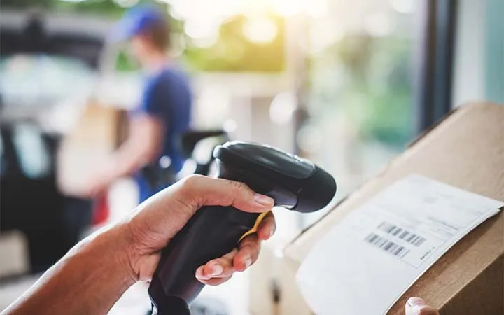 Postbote scannt Versandlabel Postbote scannt Versandlabel