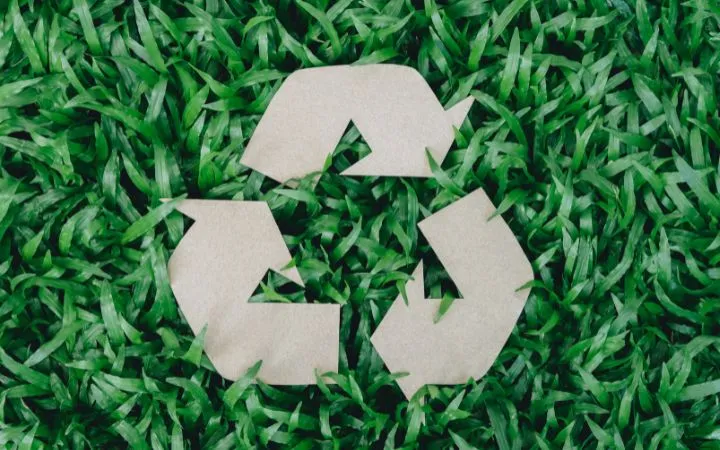 Recyclingzeichen aus Karton im Gras Recyclingzeichen aus Karton im Gras