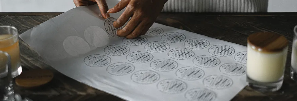 Frau löst bedruckte Bogenetiketten ab Frau löst bedruckte Bogenetiketten ab