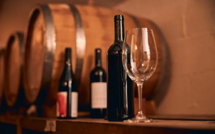 Weinflaschen und Weinglas auf einem Regal Weinflaschen und Weinglas auf einem Regal