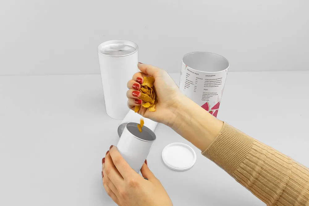 Frau befüllt Papierdose mit Cornflakes