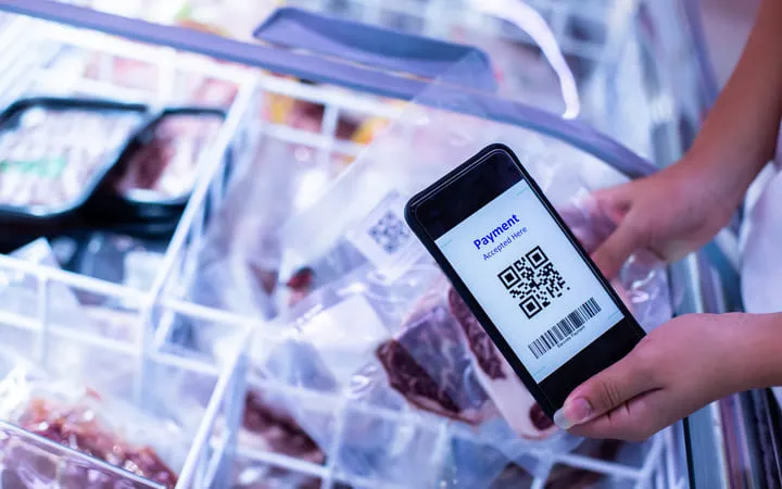 QR - Code Etikett auf einer Fleischverpackung wird gescannt im Supermarkt an den Gefrierschränken. QR - Code Etikett auf einer Fleischverpackung wird gescannt im Supermarkt an den Gefrierschränken.