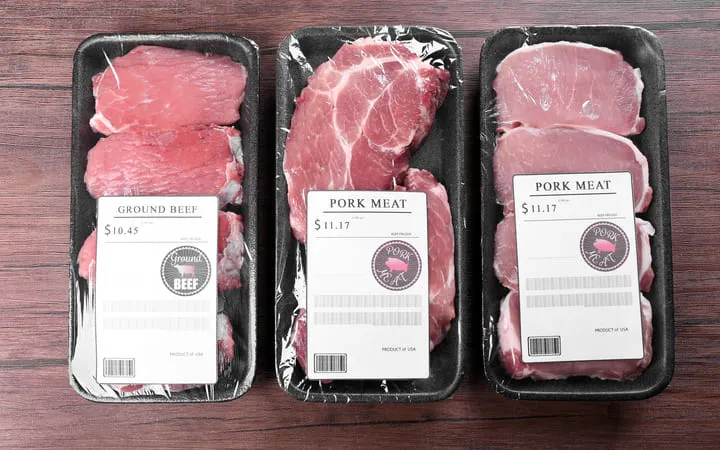 Drei Packungen Rindfleisch mit jeweils einem Etikett auf der Oberfläche mit den Angaben von Preis und Gewicht  Drei Packungen Rindfleisch mit jeweils einem Etikett auf der Oberfläche mit den Angaben von Preis und Gewicht